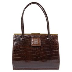 A typical late 1930s Asprey sienna-brown crocodile handbag, comprising of one compartment with one gusseted zipper pocket, two patch pockets piped with chamois-brown leather, one lipstick holder and one outer back pocket, fully lined in an ochre-brown suede lining, mounted on a gilt frame with an elongated rectangular bar clasp, suspended on a pair of self gently padded tubular arched handles, finished with a self tab. Ostrich Handbags, Crocodile Handbags, Oxblood Leather, Fur Handbags, Black Leather Top, Snake Skin Bag, Maroon Leather, Lipstick Holder, Ostrich Leather