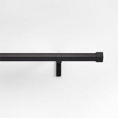 a black metal shelf with two brackets on the top and one is attached to the wall