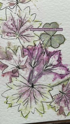 some leaves and flowers are on a piece of paper with watercolor paint in it