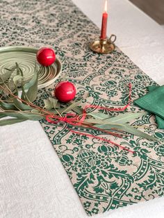 the table is set with two red apples and green napkins on top of it