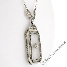 This is a gorgeous and VERY WELL MADE pendant necklace crafted during the art deco period in solid 14k white gold. It features a large, rectangular-shaped, camphor glass panel with cut corners and a stunning diamond set at its center. The pendant displays magnificent etching designs and open filigree work throughout its frame as well as the part that connects to the chain. The filigree work gives this piece its unique look and makes a special statement on this pendant. The lovely diamond is set Classic Platinum Necklaces For Evening, Antique White Gold Diamond Pendant Necklace, White Gold Diamond Necklace With Filigree For Anniversary, Anniversary White Gold Diamond Necklace With Filigree, Art Deco White Gold Diamond Necklace For Formal Occasions, Classic Silver Filigree Diamond Necklace, Art Deco Platinum Necklace With Diamond Cut, Art Deco Platinum Diamond Necklace In Silver, Antique Jewelry With Polished Finish For Evening