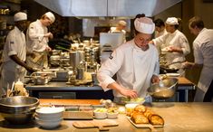 a group of chefs preparing food in a kitchen