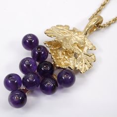 "This Amethyst Grape Necklace and Dangle Earring set is a larger size version of the other ones I have listed here. They have a natural looking grape cluster with two overlapping 14kt yellow gold vermeil grape leaves with a lot of fine detail . The necklace design contains nine 3mm. Dark Purple Amethyst gemstones and the Earrings contain eighteen gemstones. The Amethyst gemstones are clustered in a natural looking way like an actual cluster of grapes. The pendant comes with a 14kt. Gold Vermeil Amethyst Fine Jewelry For Evening, Elegant Evening Amethyst Jewelry, Purple Amethyst Jewelry For Evening, Formal Amethyst Briolette Jewelry, Hallmarked Purple Jewelry For Formal Occasions, Elegant Grape Colored Jewelry For Gift, Purple Briolette 14k Gold Jewelry, Purple 14k Gold Dangle Jewelry, Grape Necklace