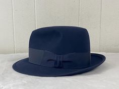 Vintage 1940s or 1950s Royal Stetson fedora hat. Made of black felt (almost looks navy blue in the right light). Black grosgrain hatband. Has a felted and triple stitched brim. Lined in satin. Brown leather sweatband. ROYAL STETSON made by JOHN B. STETSON COMPANY. Sold at J. L. Hudson's Company, Detroit.  Size 7 1/2.  2 1/4" brim. Opening measures 6 3/4" X 8 1/4".  In excellent condition. Retro Formal Fedora With Wide Brim, Retro Wide Brim Fedora For Formal Occasions, Retro Fedora Hat For Formal Occasions, Retro Fedora With Short Brim For Formal Events, Retro Fedora With Short Brim For Formal Occasions, Retro Short Brim Fedora For Formal Events, Retro Short Brim Fedora For Formal Occasions, Vintage Fitted Top Hat With Flat Bill, Retro Formal Fedora Felt Hat