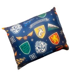 the harry potter pillow is on display in front of a white background with hogwart's crests all over it