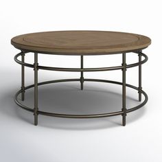 a round wooden table sitting on top of a metal frame coffee table next to a white wall