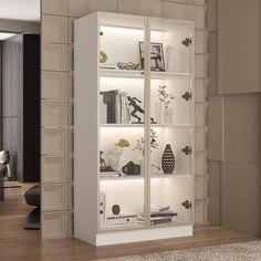 a white bookcase with glass doors and shelves in the middle of a living room