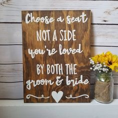 a wooden sign that says choose a seat not a side you're loved by both the groom and bride