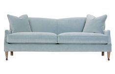 a light blue couch with two pillows on the back and one arm upholstered