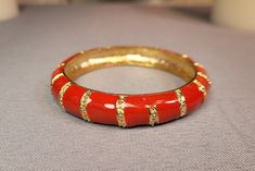 Red & gold, snaky patterned enamel paint, alloy metal slip-on bangle bracelet. Silver colored inside of band. Handmade Red Enamel Bracelets, Red Metal Bangle For Party, Red Enamel Bangle Bracelets, Red Enamel Bangle Bracelet, Red Enamel Bangle Jewelry, Red Round Metal Bangle, Vintage Red Metal Bangle, Red Enamel Bangle, Serpent Bracelet