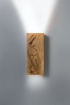 a square wooden object on a wall with light coming from it's back side