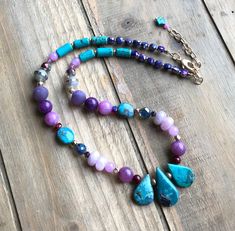 "Fun and flirty, this boho beauty combines turquoise, amethyst, jade, agate, kunzite, lepidolite, Czech glass and gold plated beads to create a necklace with no shortage of color and personality. While 3 important genuine turquoise teardrops - approx. 16x 12mm - form the focal of the piece, gemstones in assorted colors, shapes and sizes serve as the body and Czech glass beads and crystals provide just the right amount of sparkle. The overall result is a piece that looks like it could walk out of White Gemstone Necklace, Sundance Style Jewelry, Colorful Beaded Necklace, Stone Diy, Sundance Jewelry, Nice Night, Purple Accessories, Sundance Style, Blue Stone Necklace