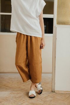 Summer linen culotte trousers.Wide legs getting narrower towards the bottom.There is a wide rubber band in the waist.Pockets in the side stitches.Color: honey and cinnamonFabric: 100% linenWash in a washing machine in 30 degrees Celsius. To prevent the fabric from shrinking, first washing should be in 20 degrees CelsiusThe model (176 cm) is wearing the size M/L.Sizes:XS / SWaist: 70-90 cm Hips: 110 cmTotal length: 82 cmLeg width (bottom): 43 cmM / L Waist: 80-95 cm Hips: 114 cmTotal length: 86 c Brown Linen Bottoms For Summer, Brown Linen Summer Bottoms, Summer Culottes With Relaxed Fit, Summer Relaxed Fit Ankle-length Culottes, Summer Brown Linen Bottoms, Summer Ankle-length Relaxed Fit Culottes, Yellow Linen Bottoms For Spring, Brown Baggy Linen Bottoms, Orange Baggy Bottoms For Spring