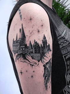 a man with a hogwarts castle tattoo on his arm