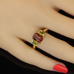 Rare and unusual orange Tourmaline accented with twin half moon Peridot set in gold rhodium over Sterling Silver ring. This gorgeous, clean, sparkling Tourmaline is that fantastic orange shade that is so covented. This is a 2.70ct beauty straight from one of our favorite vendors in the mountains outside of Rio de Janeiro. The Peridot are just the right shade of green to accent the orange of the Tourmaline. No changes by seller. This is a sizable 8. Sizable by your local jeweler. MR2328 Orange Tone, Rare Beauty, Peridot Ring, Green Peridot, Tourmaline Ring, I Love Jewelry, Vibrant Green, Three Stone Rings, Shades Of Orange