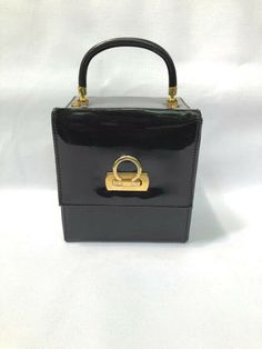 Chic small black patent leather cube purse with gold metal clasp. Hard case style. Good condition.Measures 5.5 wide x 6 h. 3" strap drop. Inside is surprisingly roomy with accordion fold and holds alot.  All sales final -from a smoke free home. Terms and Info regarding items I sell: Items are from a smoke free home. Many items are sourced specifically to resell at reasonable prices. I make every effort to inspect and reveal any condition issues I find and only select and list great items I