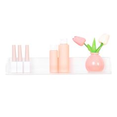 three bottles with flowers in them sitting on a shelf next to some tubes and vases