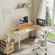 a computer desk with two monitors and a laptop on it in front of a window