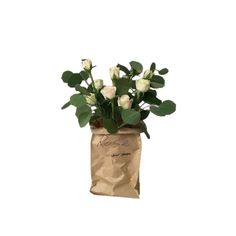 a paper bag filled with white roses and greenery