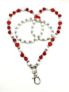 a red and white beaded lanyard with a pair of scissors hanging from it