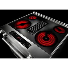 an electric stove with red lights on the front and side burners in stainless steel