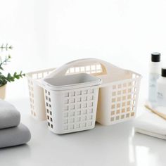 a white basket sitting on top of a table next to towels and other bathroom items