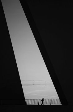 a person is walking across a bridge in the dark