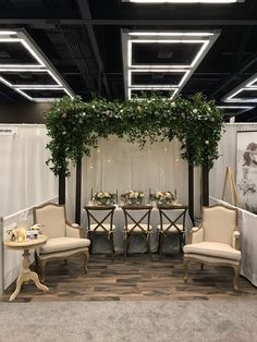 the booth is decorated with greenery and chairs