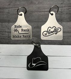 two metal tags with the words ride, rank and make bank written on them hanging from hooks