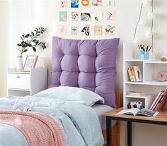 a bed room with a neatly made bed next to a desk and bookshelf