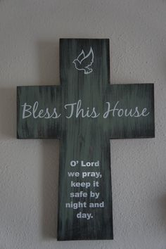 a wooden cross hanging on the wall that says,'bless this house o'lord we pray, keep it safe by night and day