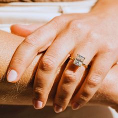 a close up of a person's hand with a ring on their finger and arm