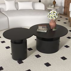 two black tables sitting on top of a white floor next to a couch and coffee table