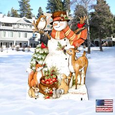 a snowman with deer and birds on top of a christmas tree in the snow