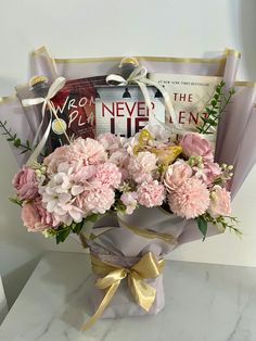 a bouquet of pink carnations in a gift bag