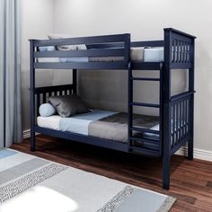 a blue bunk bed with two drawers underneath it and a rug on the floor next to it