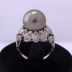 Ancient Tahiti Pearl ring Platinum diamonds Beautiful ring with Pearl central grey of Tahiti's 11 mm surrounded of petals in Platinum with diamonds size glossy set a total of 0, 80ct. His weight total is of 9, 1grs. Its height is of 14 mm, its carving 10-5 1 / 2 (USA) this ring is can enlarge and shrink in a workshop of jewelry. See the photos if has a question write respond to it as soon as possible. This top quality 11 mm Tahitian pearl gray is held aloft by Platinum, pave set with 0.80 ct tot Tahiti Pearl, Diamond Ring Platinum, Tahitian Pearl Ring, Pearl Gray, Pearl And Diamond Ring, Platinum Diamond Rings, Jewelry Workshop, Ring Antique, Akoya Pearls