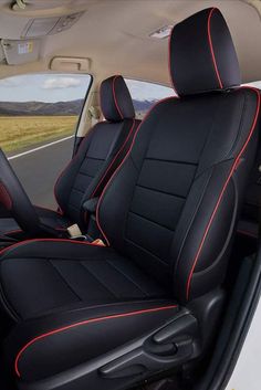 the interior of a car with black and red stitching on the front seat covers