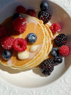 pancakes with berries and blueberries on a white plate