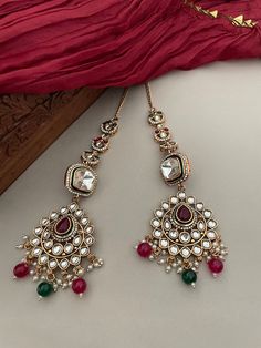 A great addition to your lavish jewelry collection! Beautiful kundan earrings accented with ruby red and emerald green stones. The dash of diamonds  adds glam to your outfit. Details: Earrings Length-1.40 Inches Weight of Each Earring-10 grams All products are manufactured using traditional skills from our rich heritage of crafts.  The process of these crafts is essentially manual. Hence, any irregularities or variations are an inherent part of these handcrafting processes. Red Kundan Jewelry With Gemstone, Red Kundan Fusion Earrings, Red Kundan Dangle Earrings, Festive Red Kundan Chandelier Earrings, Designer Wedding Jewelry, Red Meenakari Dangle Earrings, Emerald Green Stone, Polki Earrings, Kundan Earrings