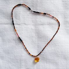 Petit cœur ambre de lumière. Pièce unique. Misez sur la simplicité pour ce petit collier qui s'attachera à votre cou comme un porte-bonheur. Pierre du soleil, l'ambre se gonfle de sa belle lumière et rayonne de tout son cœur ♡  Ambre de Lituanie, certifié authentique par la boutique-fournisseur Les Trésors du Brésil, située à Manosque dans Les Alpes de Hautes Provence.  Enfilage de perles rocailles dorées et cuivrées, perles de verre noires à facettes. Fermoir en inox. Baltic Amber Gemstone Necklaces, Brown Natural Stone Jewelry Gift, Brown Natural Stone Jewelry For Gifts, Brown Jewelry With Natural Stones As Gift, Brown Natural Stone Jewelry As A Gift, Brown Teardrop Jewelry For Gift, Brown Gemstone Beads Jewelry Gift, Gift Brown Gemstone Beads Jewelry, Handmade Heart-shaped Jewelry For Meditation