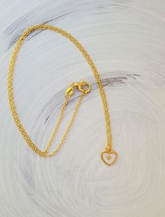 This sweet mustard seed necklace is a wonderful little piece, perfect for any occasion. The tiny mustard seed is suspended in glassy resin in a small textured gold heart. A wonderful reminder to keep the faith. #mustardseed Gold Charm Necklaces With Round Pendant, Gold Charm Necklace With Round Pendant, Delicate Gold Heart Pendant Necklace, Delicate Gold Necklace With Heart Charm, Tiny Gold Plated Gold Necklaces, Tiny Gold Round Pendant Necklace, Gold Tiny Round Pendant Necklace, Gold Plated Heart Beads Charm Necklace For Gift, Gold Plated Charm Necklaces With Heart Beads For Gift