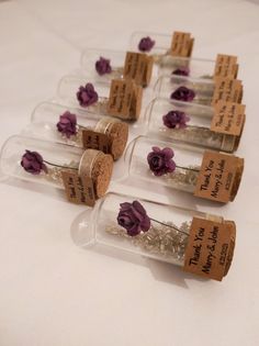 small bottles with tiny flowers in them sitting on a table