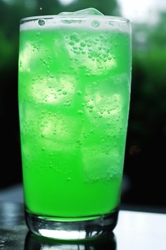 a tall glass filled with green liquid