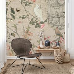 a chair sitting in front of a wall with flowers and birds on it