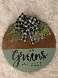 a wooden sign that says the greens est 2011 on it with a bow and greenery