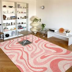 a living room filled with furniture and a pink rug