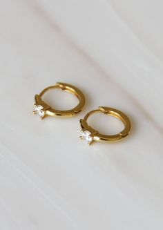 Featuring a tiny round CZ. Perfect for every day and layering. These earrings are meant to be worn close around the earlobe. Base Material: High Quality 925 Sterling Silver Finish: 18K Gold or Platinum Measurements: 9mm hoop, 2mm stone Nickel Free Made in United States Weight: 2.1 oz (59 g) Dainty Cubic Zirconia Round Hoop Earrings, Dainty Cubic Zirconia Hoop Earrings, Dainty Round Huggie Earrings, Single, Dainty Round Huggie Earrings, Dainty Single Round Huggie Earring, Tiny Round Huggie Earrings For Anniversary, Minimalist Hoop Earrings For Gifts, Dainty Round Cut Huggie Earrings As Gift, Everyday Round Cubic Zirconia Cartilage Earrings