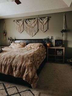 a bedroom with a large bed and two hanging decorations on the wall above it's headboard