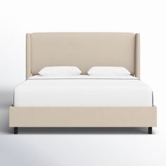 a bed with white sheets and pillows on it